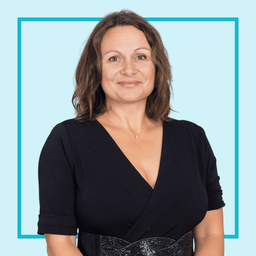 Light blue background with image of Dr Nancy Doyle wearing a blue blouse, smiling at the camera.