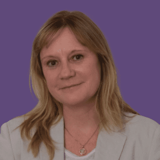 Profile picture of Angie Alderman, smiling at camera wearing a beige blazer and white t-shirt