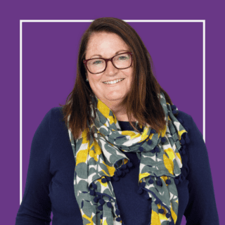 Purple background with image of Jacqui Wallis, wearing a scarf and glasses and smiling at the camera