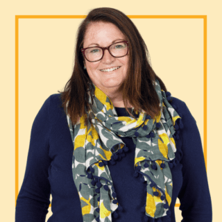 Light purple with image of Jacqui Wallis, wearing a scarf and glasses and smiling at the camera.