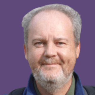 Profile picture of Ken Smith, smiling at camera, wearing blue scarf and green shirt.