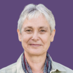 Profile picture of Elisabeth Goodman, smiling and wearing a shirt and colourful scarf.