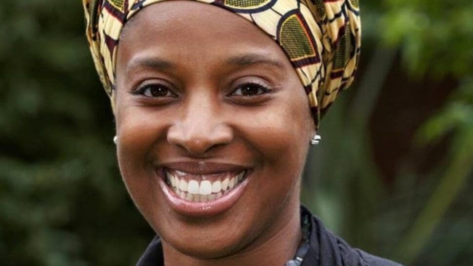 Profile picture of Marcia Brissett-Bailey wearing patterned head scarf and smiling.