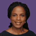 Profile picture of Claudine Charles, smiling at camera wearing a black top.