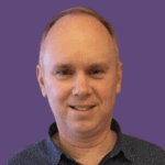 Profile picture of Simon Harris, smiling and wearing a patterned shirt.