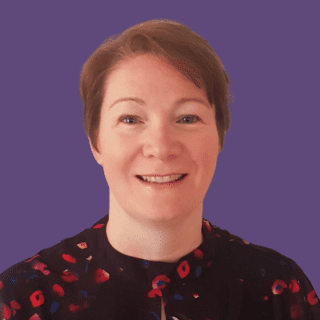 Profile picture of Aileen Carson, smiling at camera wearing a black top with red dots on it.