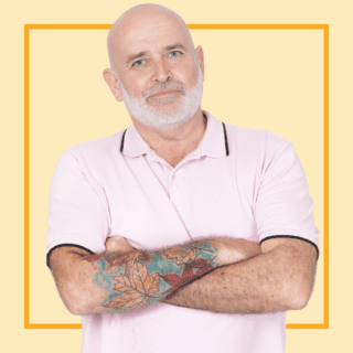 Light yellow background with image of Paul Stevenson, wearing a pink polo shirt and smiling at the camera.