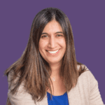 Image of Narinder Sheena in a beige blazer and blue t-shirt, smiling at the camera.