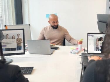 Man and two women sat at desks using computers to complete Genius Managing Neurodiversity eLearning
