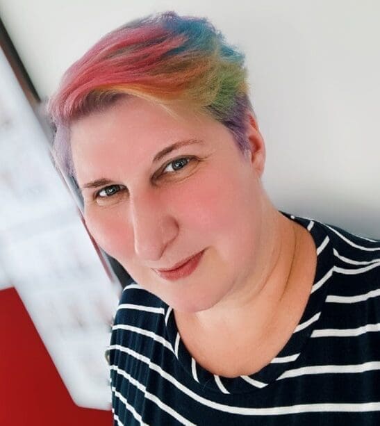 Image of Naomi Johnson, smiling at the camera and wearing a stripey black and white t-shirt