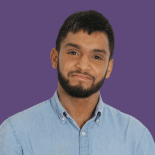 Afsar Ali smiling at the camera, wearing a light blue shirt.