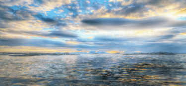 Image of the calm sea on a sunny, cloudy day