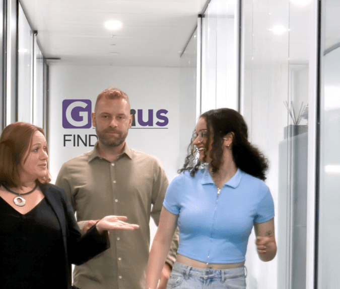 Image of two women and a man walking down an office corridor, with the Genius Finder logo in the background